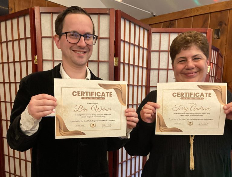 Two people holding certificates and smiling.
